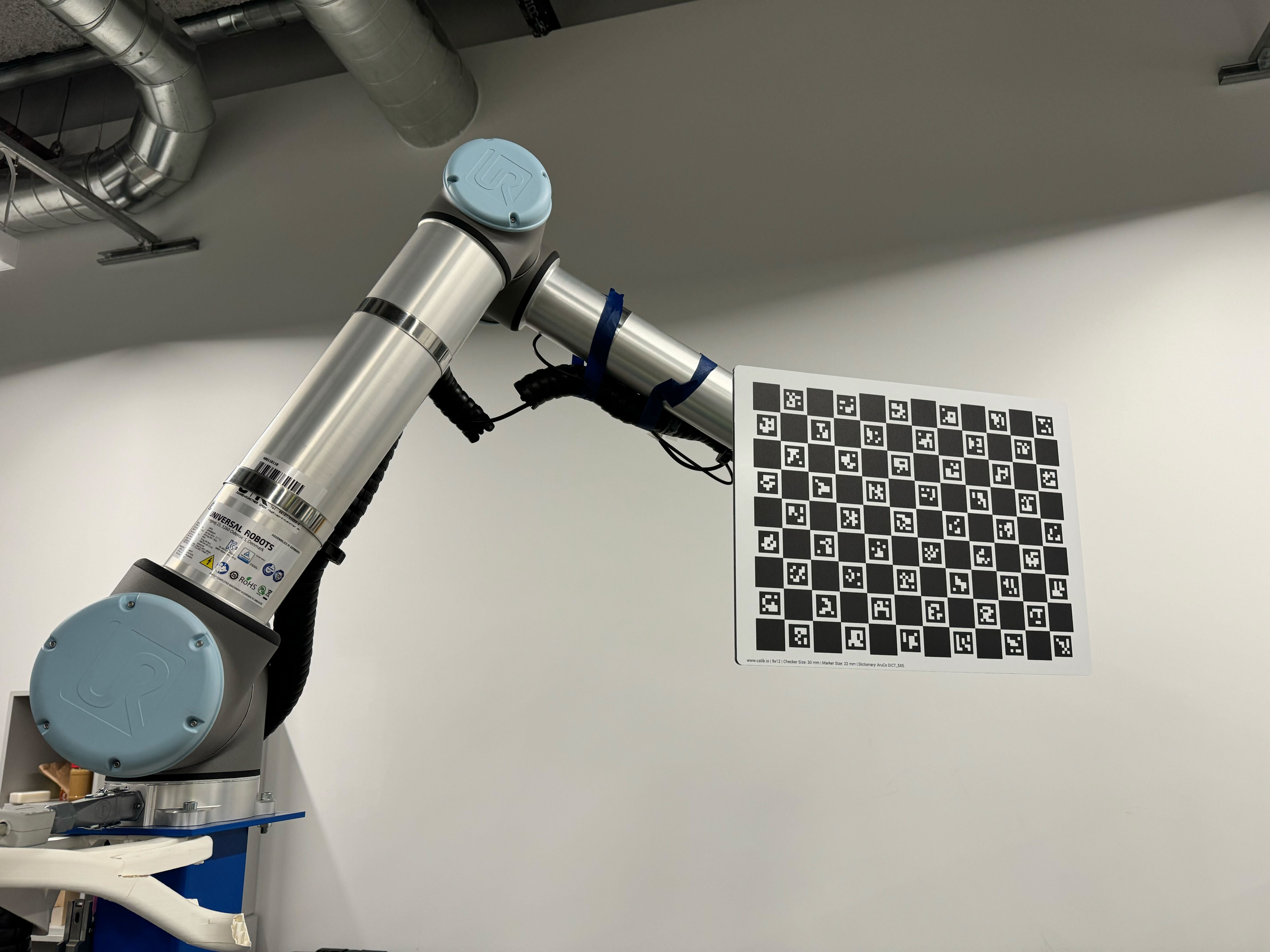 https://media.githubusercontent.com/media/NVIDIA-ISAAC-ROS/.github/release-4.1/resources/isaac_ros_docs/getting_started/manipulator_camera_calibration/ur10_w_calibration_target.jpg/